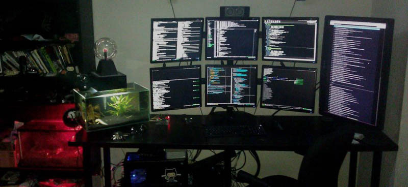 Seven monitors on a desk for programming